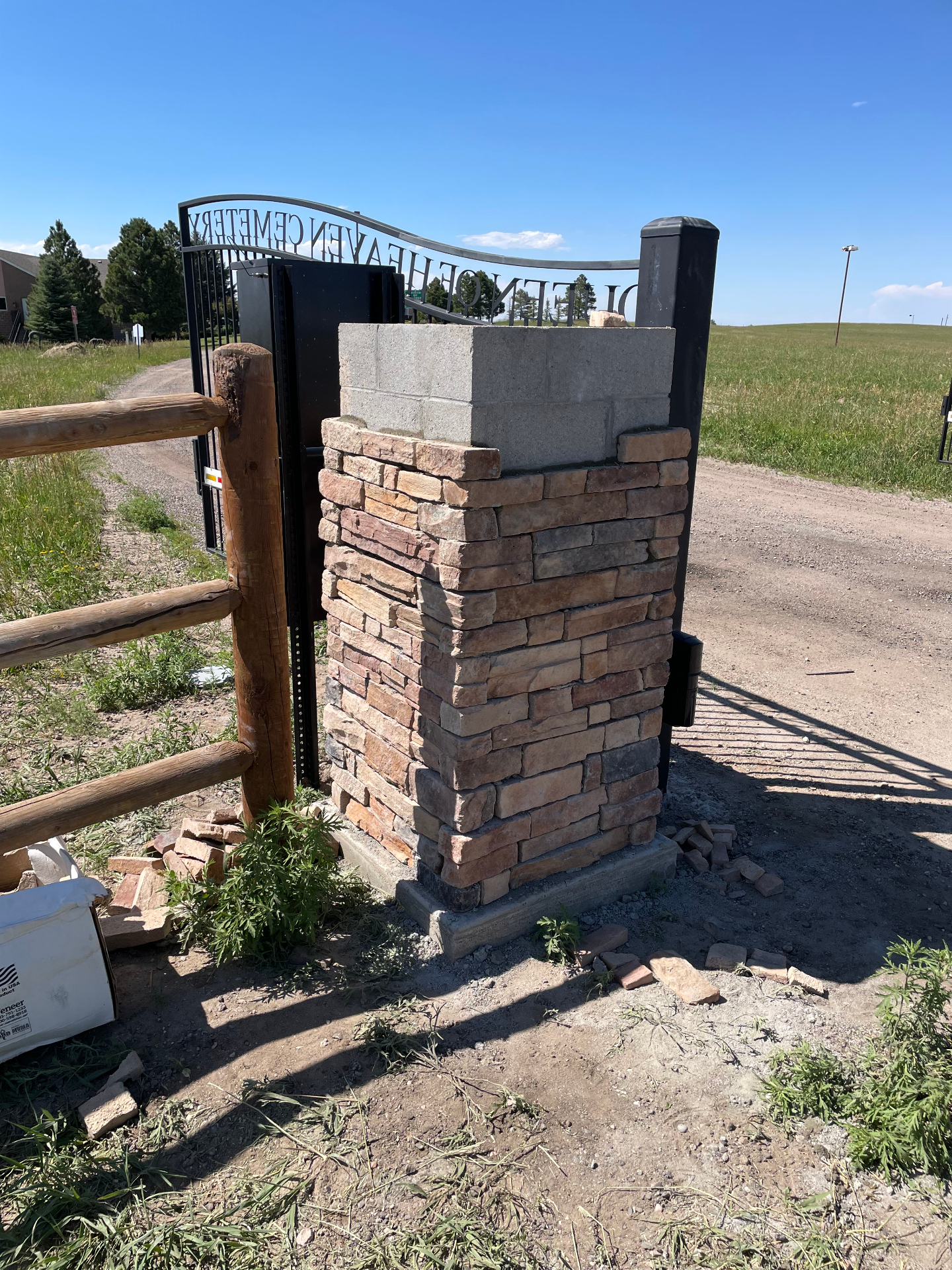 Finished stacked-stone entry column with iron gate