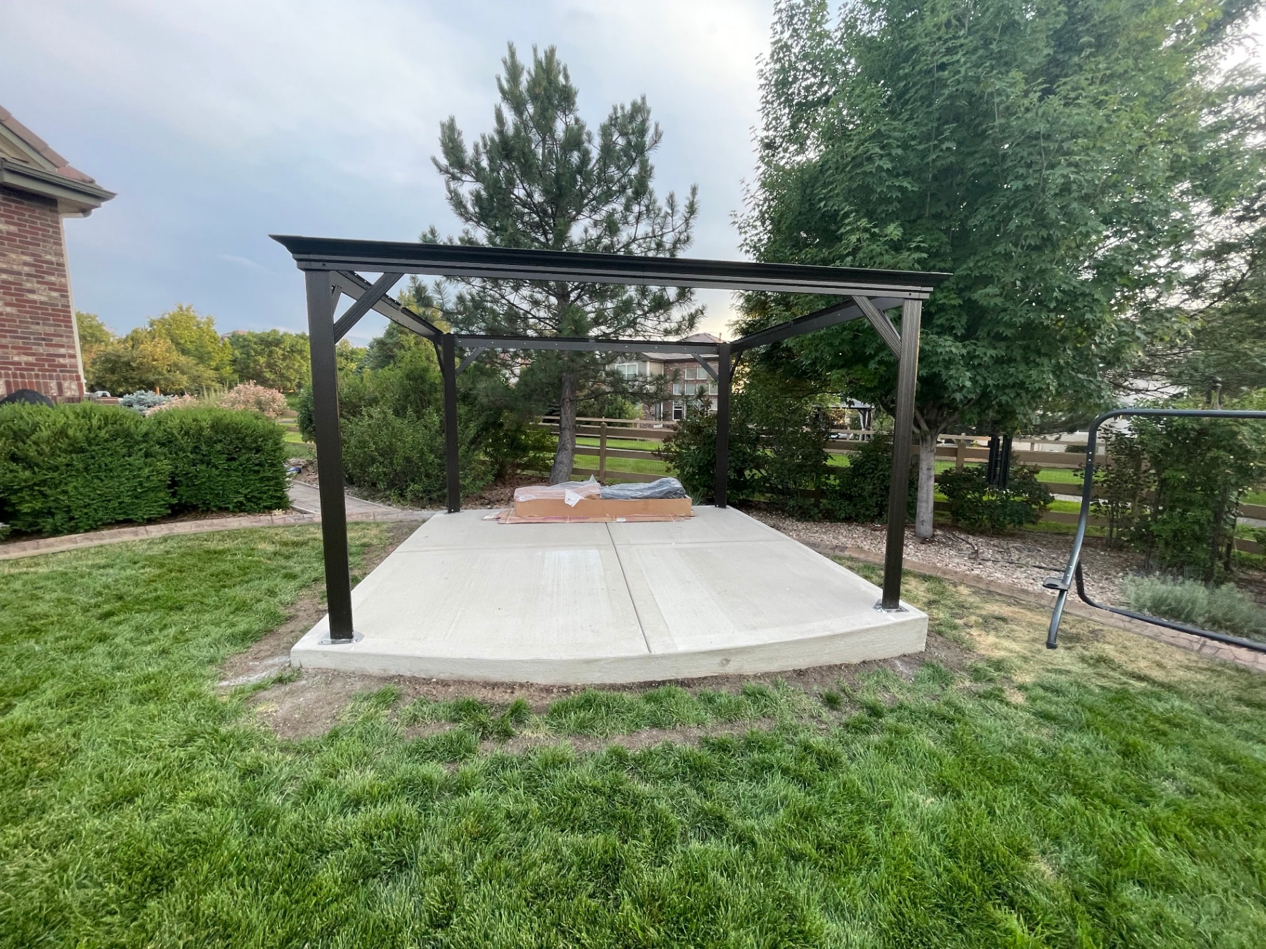 Finished concrete pad with freestanding pergola installed