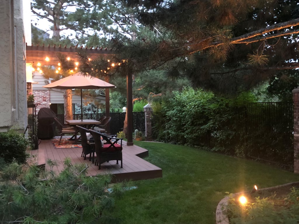 Pergola at twilight with string lights over outdoor dining area
